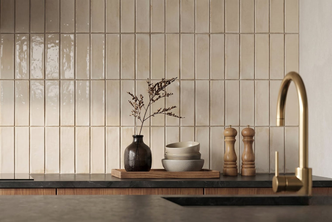 Modern kitchen with vertical cream tiles and gold faucet accents.
