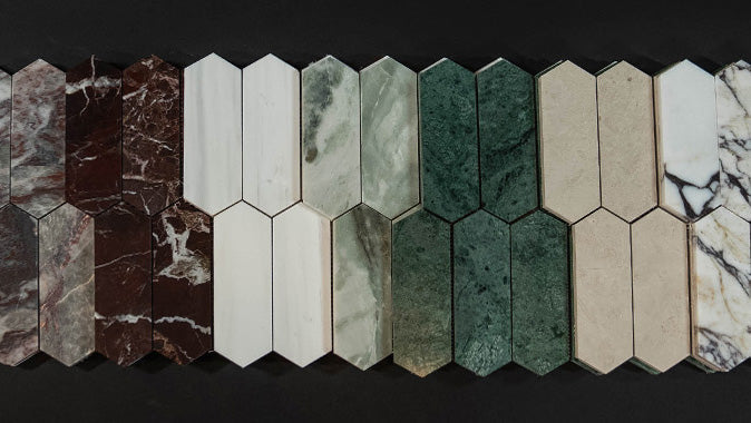 Various colors of picket-shaped marble tile samples on black background.