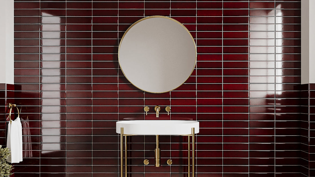 Modern vanity sink with round mirror against glossy burgundy tiles