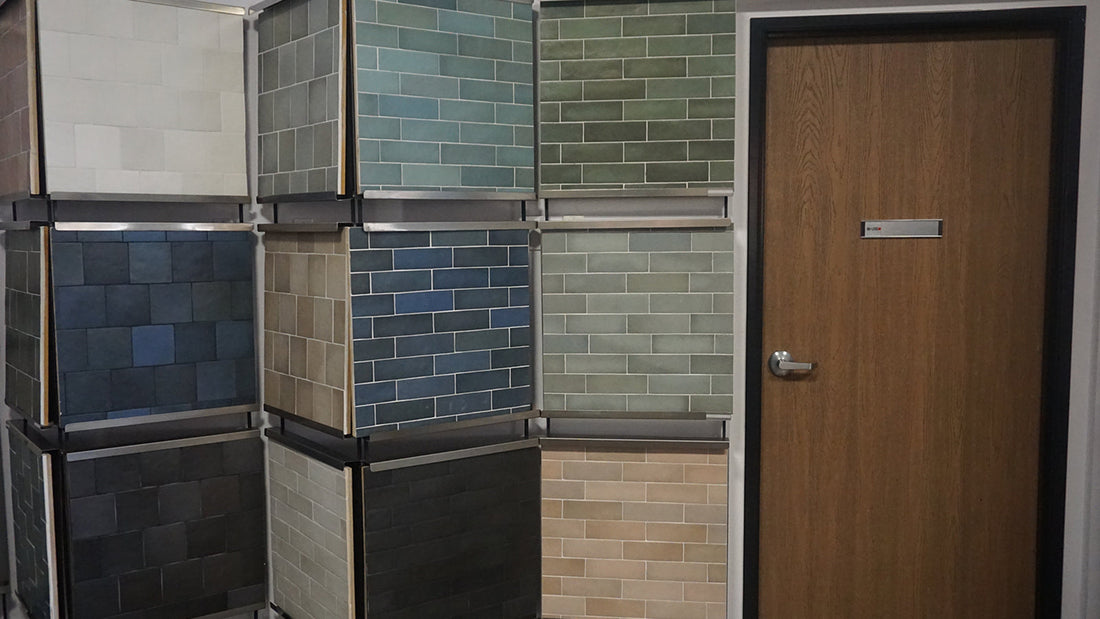 Display of various colorful subway tile samples near a door.