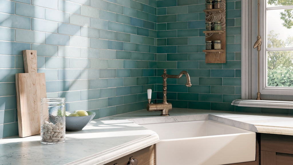 Charming cottage kitchen featuring a vibrant teal subway tile backsplash, white farmhouse sink, and a brass faucet.