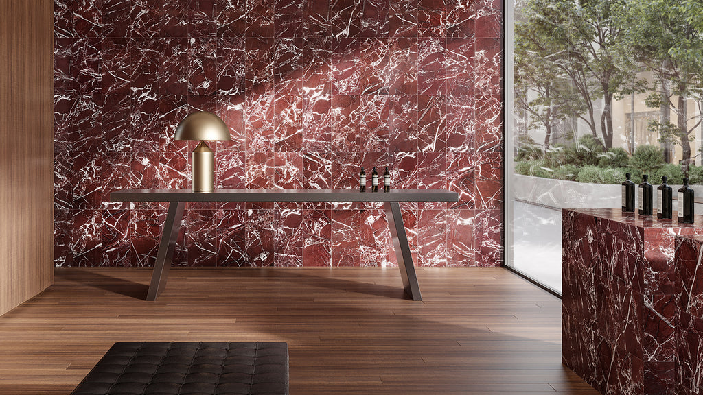 Rectangular red marble-look porcelain wall tiles used on a statement accent wall behind a minimalist desk.