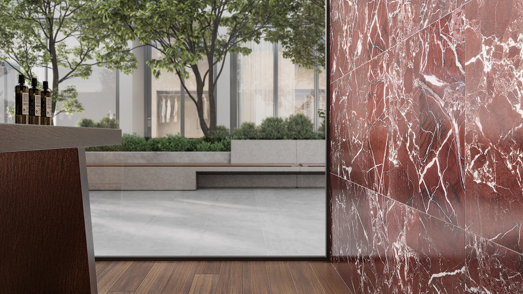 An architectural space featuring a luxury crimson marble feature wall, wood flooring, and an outdoor courtyard view.