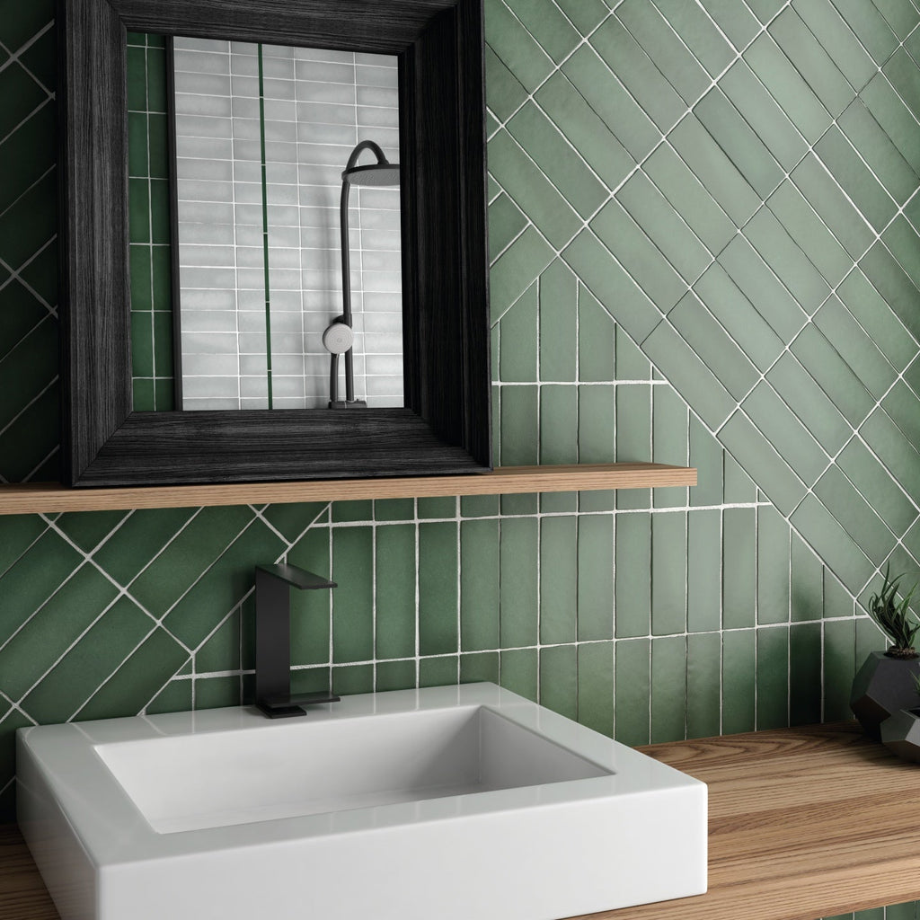 Modern bathroom vanity featuring textured green ceramic wall tiles, a white vessel sink, and a black framed mirror.