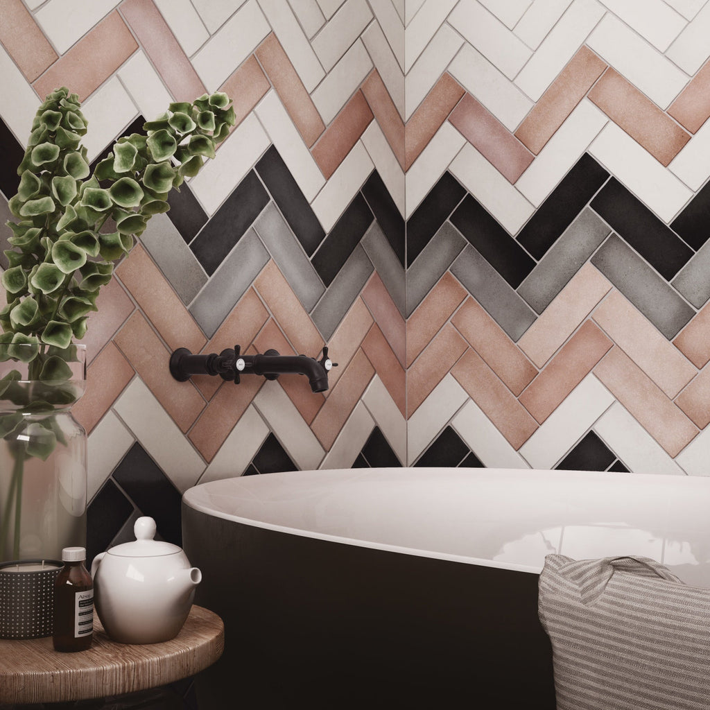 Modern bathroom corner featuring a vibrant herringbone accent wall, matte black fixtures, and a freestanding soaking tub.