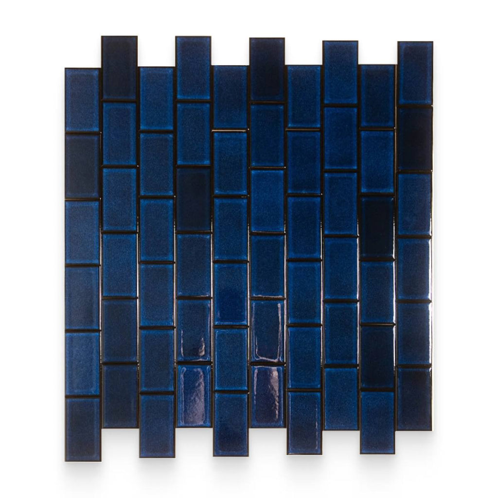 A sample of glossy deep blue vertical running bond mosaic tiles against a black background.